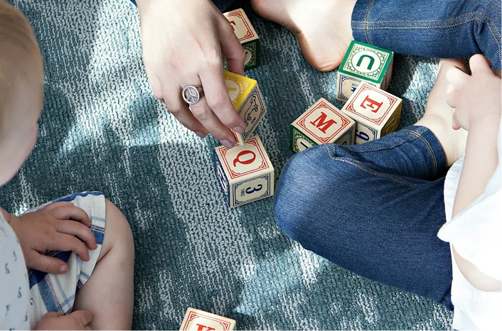 People playing with letter and number cubes