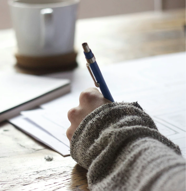 Person writing on a piece of paper