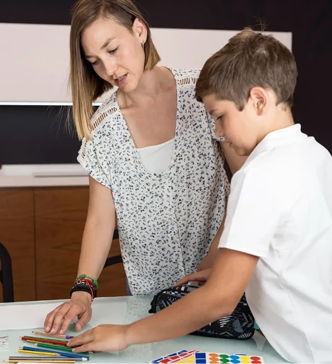 Woman helping a child choose a colored pencil